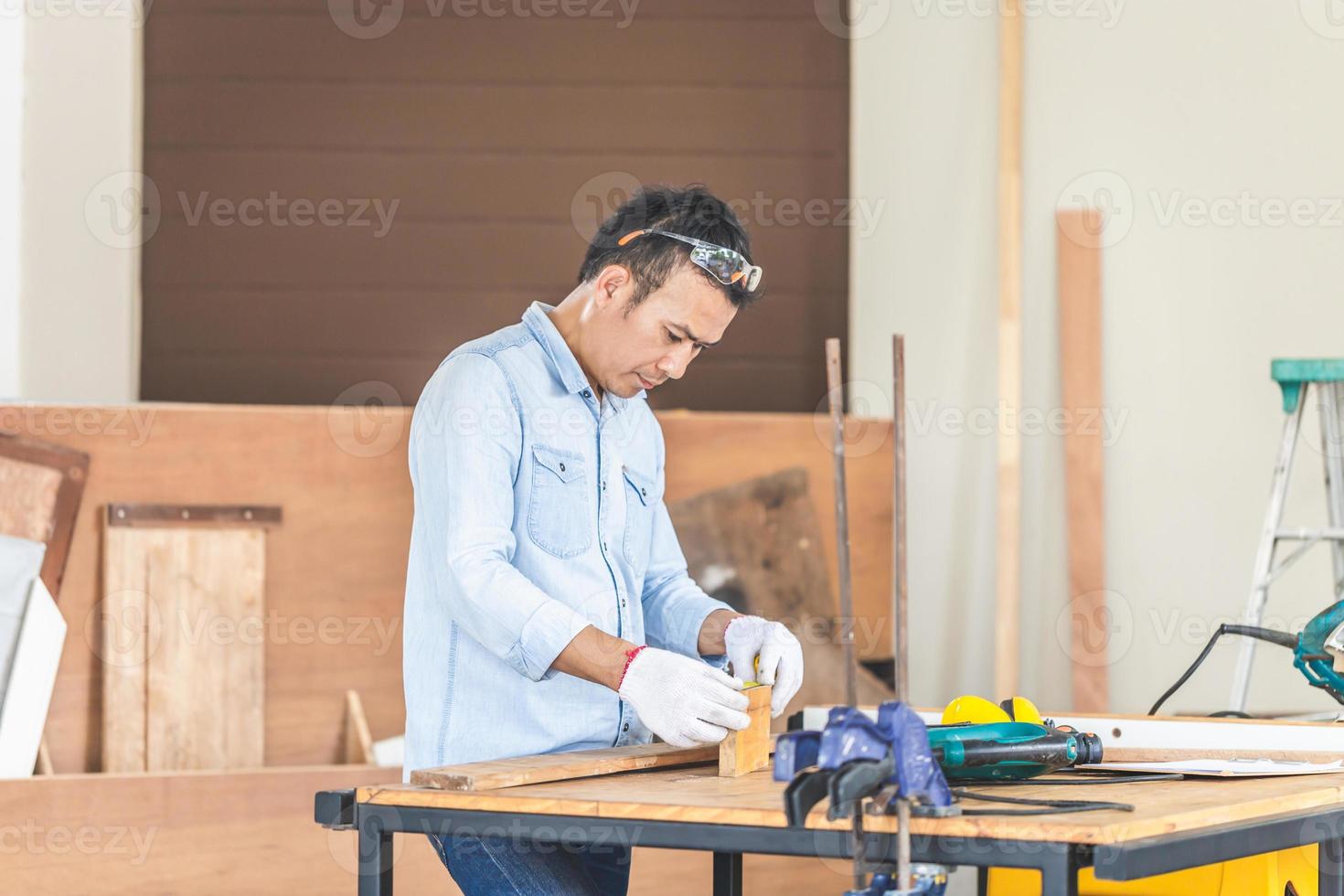 Carpenter working with equipment on wooden table in wood workshop, Technical man doing woodwork in carpentry shop photo