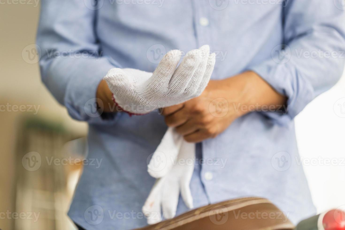 Mechanic wears gloves fixing motorbike in workshop garage, Man repairing motorcycle in repair shop, Repairing and maintenance concepts photo