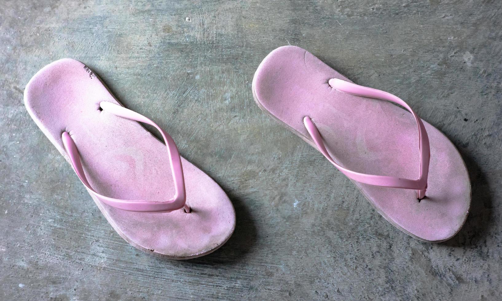 a pair of worn out pink sandals photo