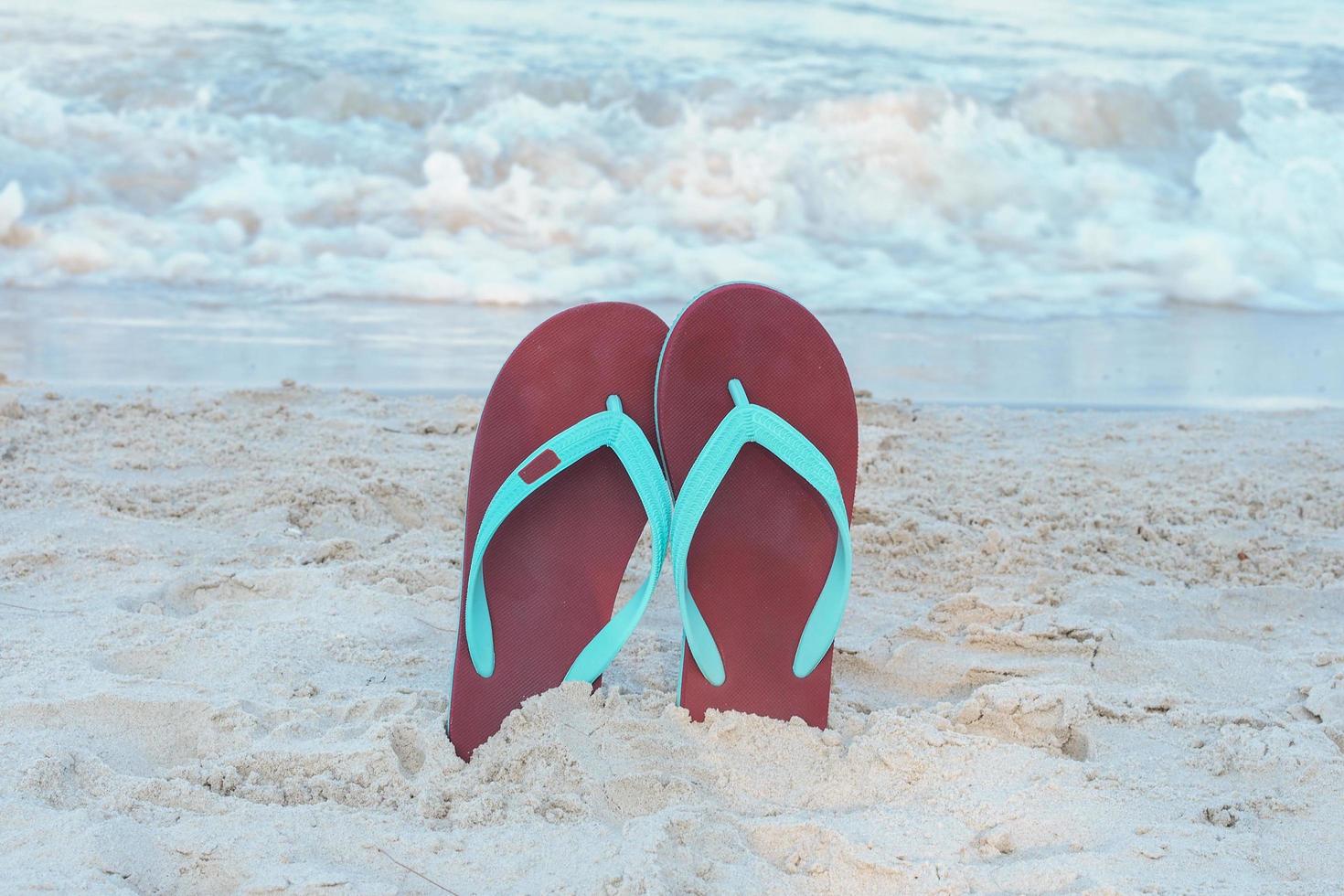 Slippers from a sand on a beach, relax concept. photo