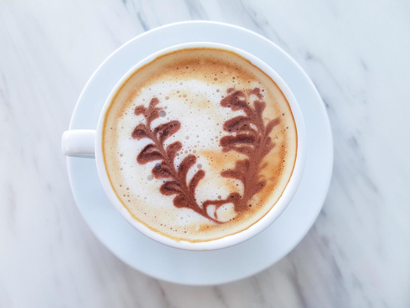 Top view art of coffee latte in white cup. photo