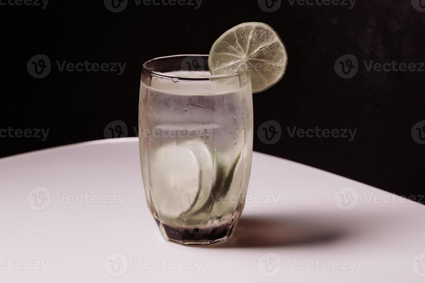 jugo de limón en un vaso transparente con lima decorativa foto