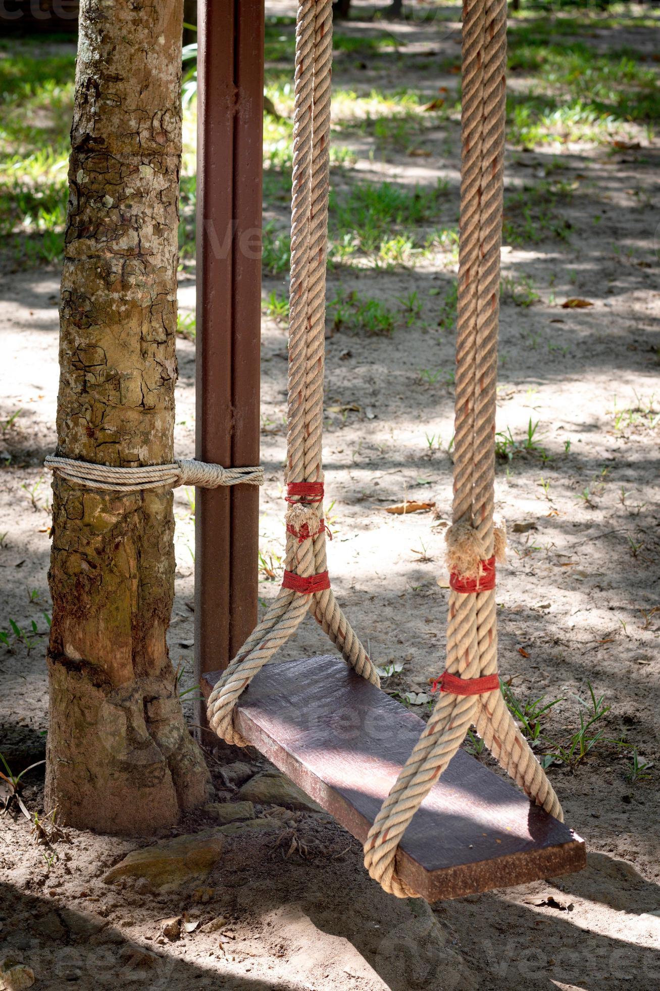 A wooden swing with twine tied to a tree 8036962 Stock Photo at Vecteezy