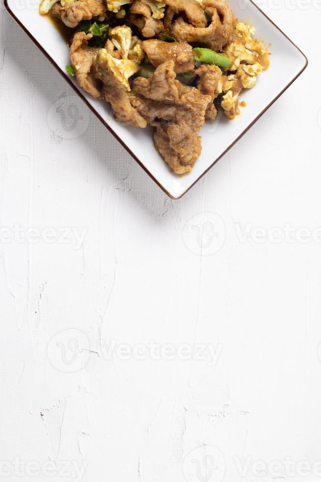 Stir Fried Pork with Green Curry Paste in a White Background photo
