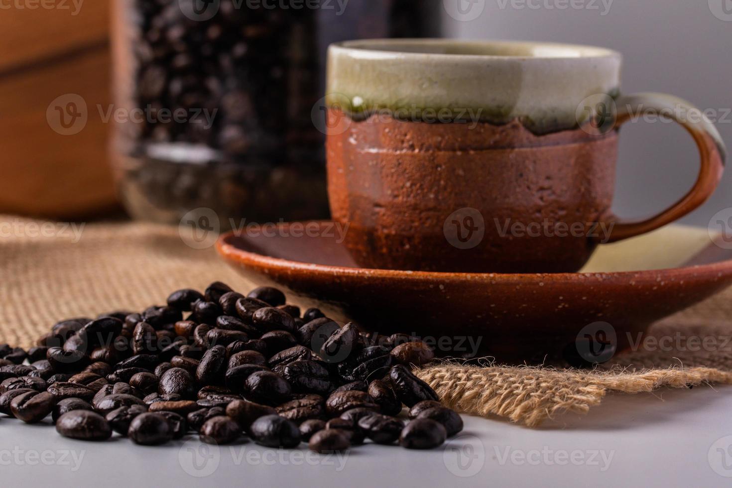 Robusta coffee beans and brown ceramic coffee cups photo