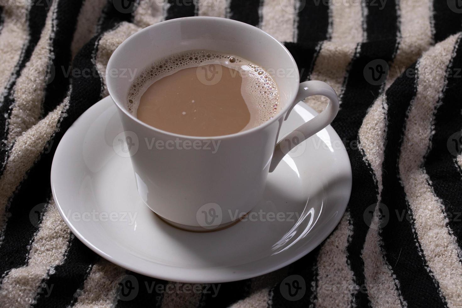 Coffee in a cream colored mug on striped background photo