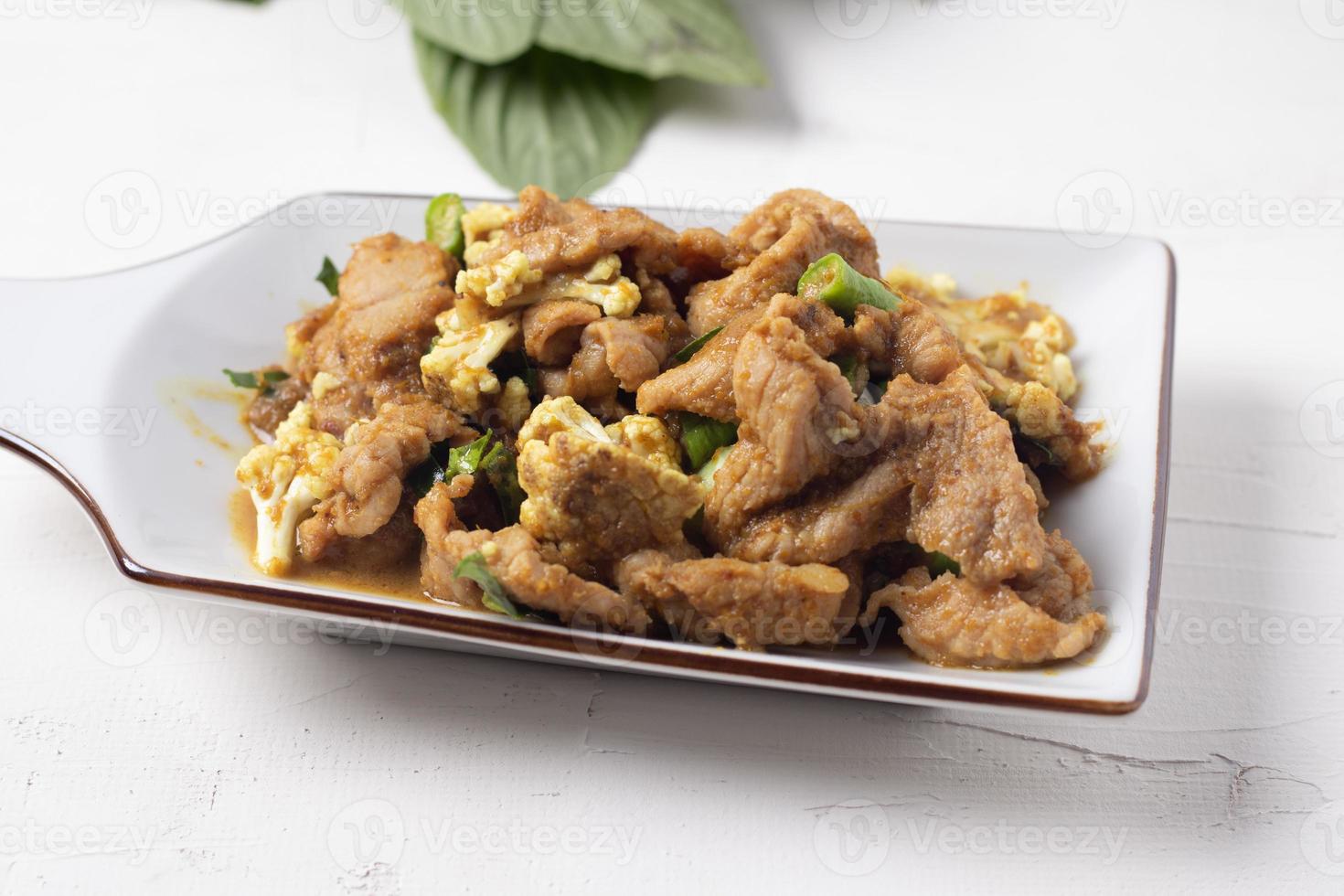 Stir Fried Pork with Green Curry Paste in a White Background photo