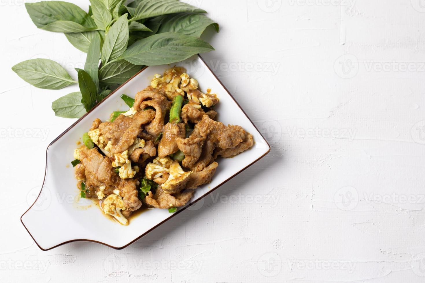 Stir Fried Pork with Green Curry Paste in a White Background photo