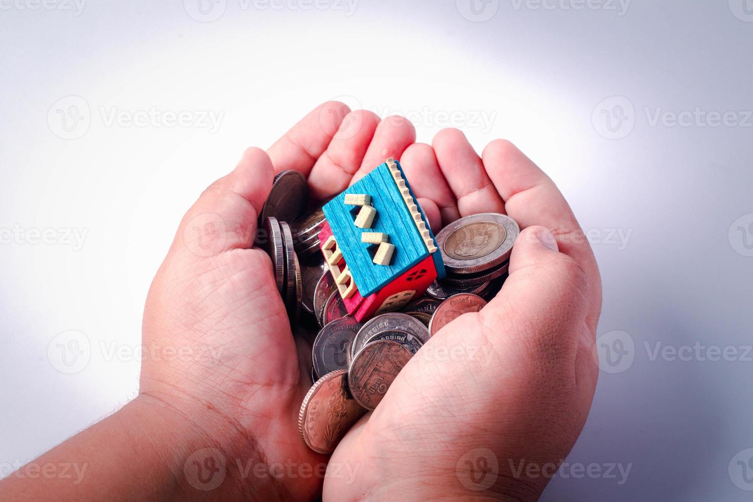Money in the hand, the top is the house. Concept of mortgage, money saving, real estate investment and house loan financial. photo