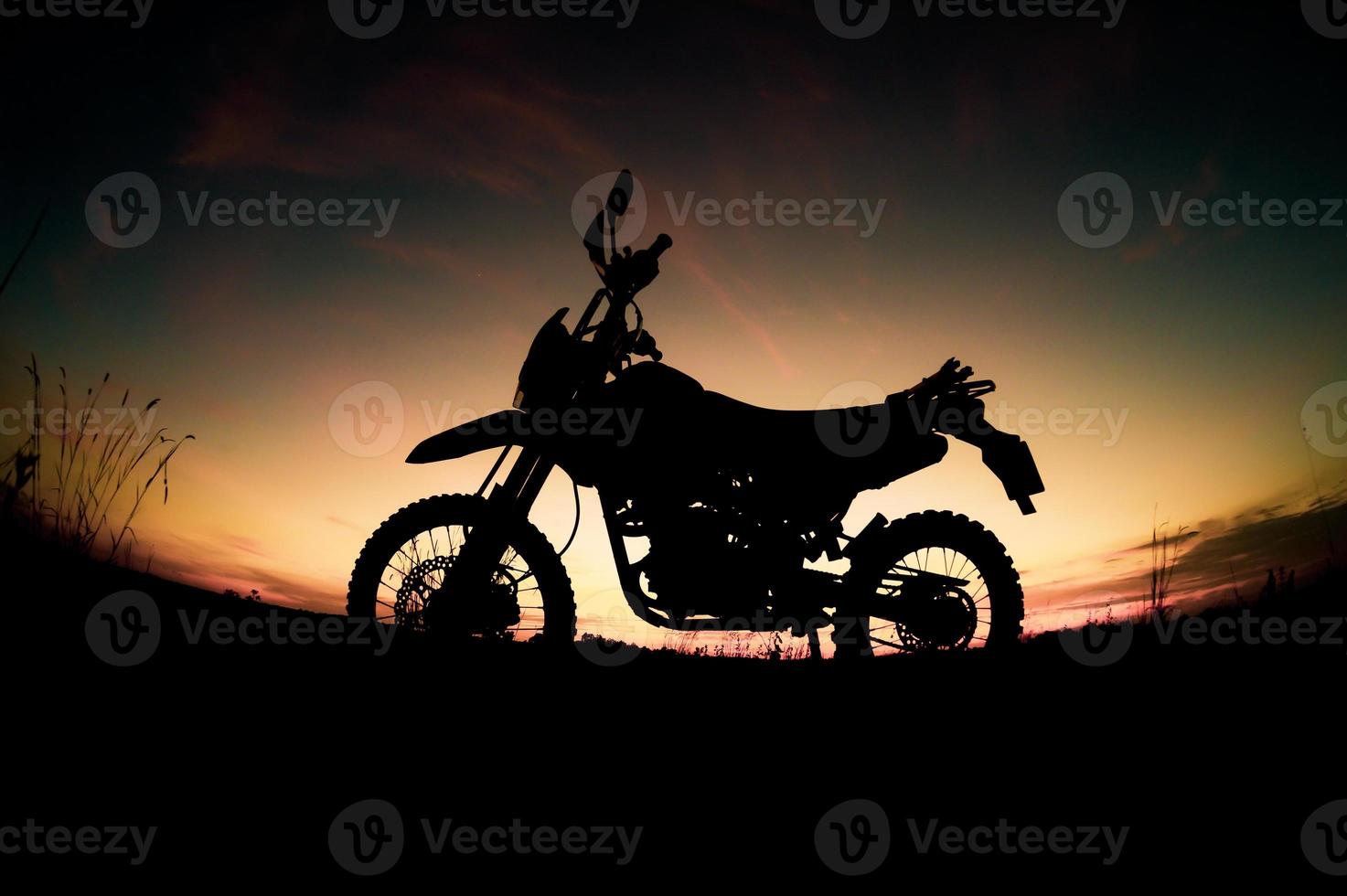 parque de silueta de motocross de motocicleta turística en la montaña por la noche. concepto de viaje de aventura foto