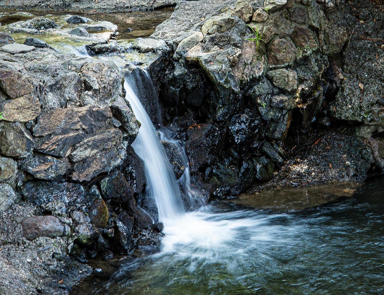 cascada que fluye sobre rocas a un pequeño pnd foto