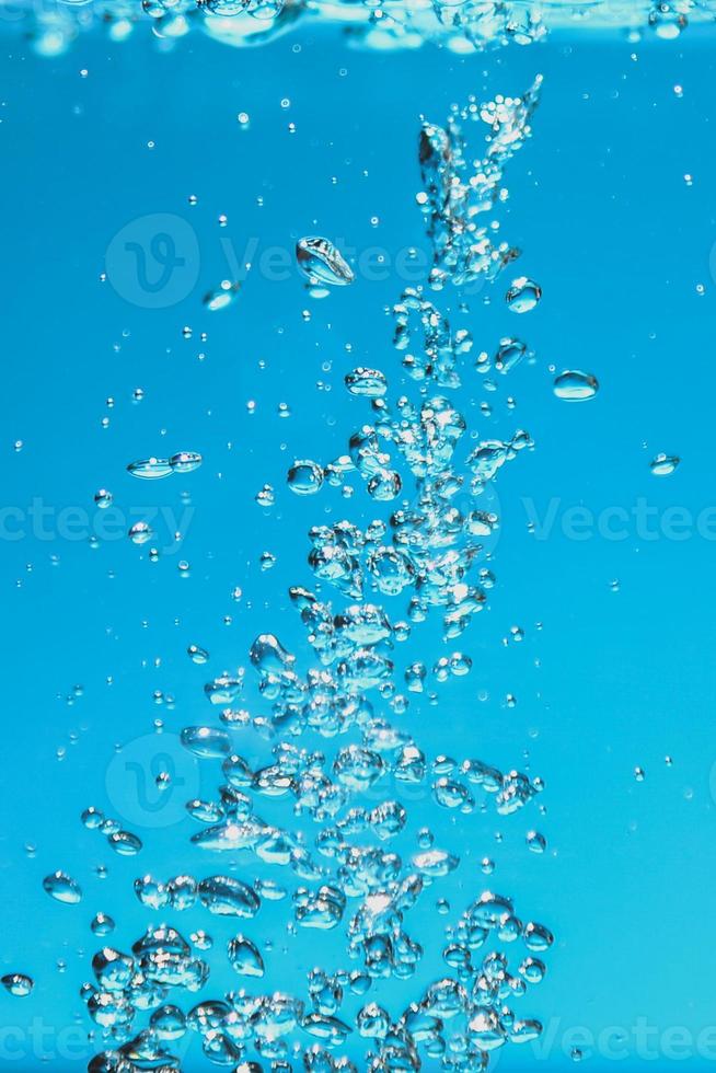 Abstract background image of bubbles in water. Clean water with water droplets and waves. Fresh water a glass with bubbles blue background. photo