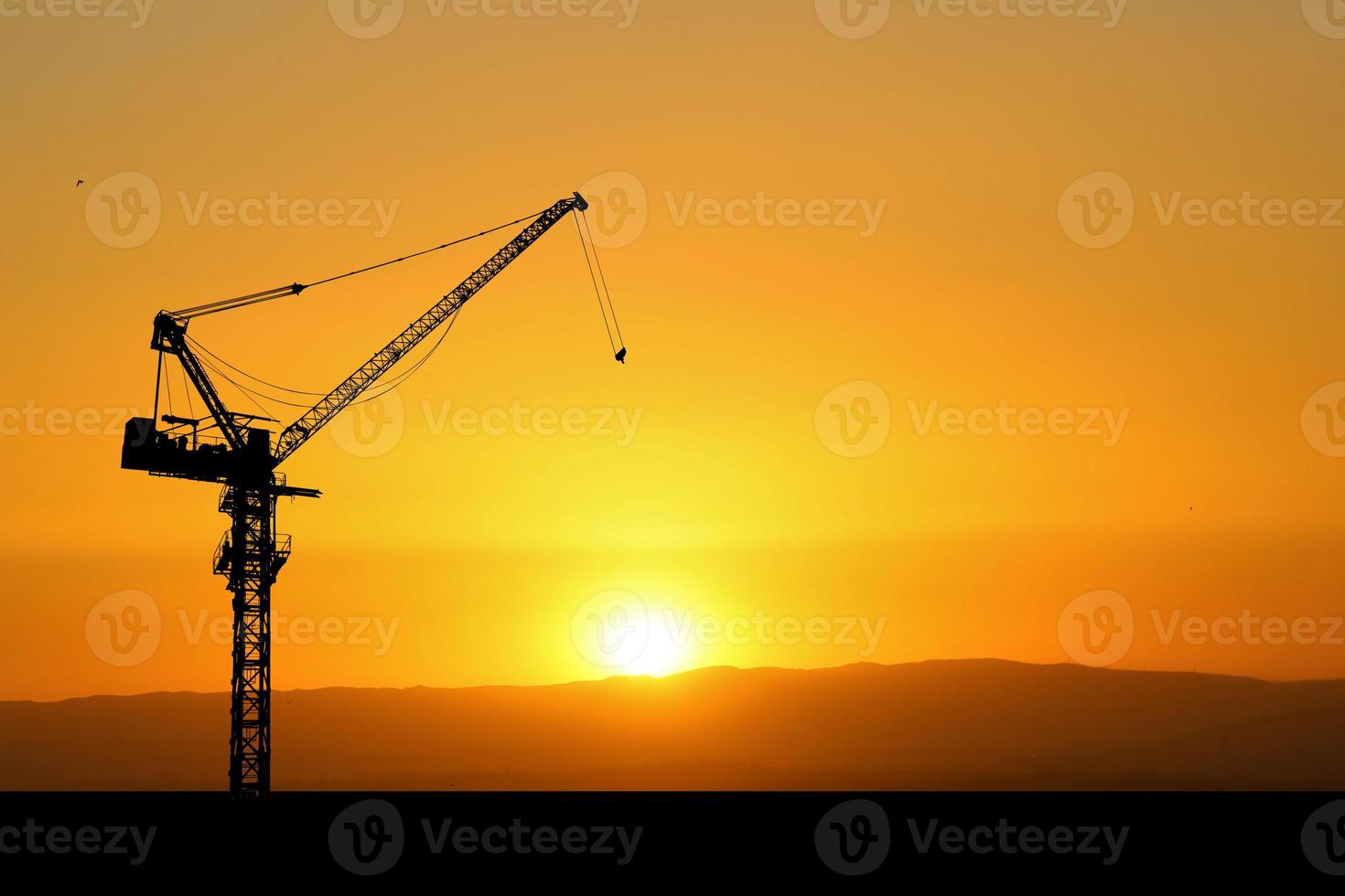 silueta de una grúa en un sitio de construcción. concepto de grúa para la industria de la construcción foto