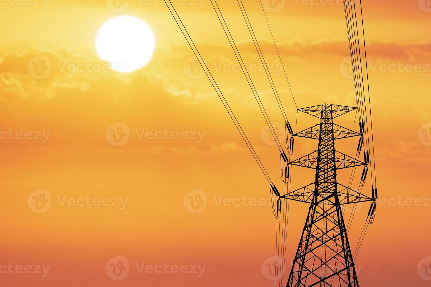 Silhouette of high voltage poles with electric wires. Silhouette of high voltage power line cables in an orange evening sunset. Steel structure of electric poles. electric power transmission concept photo