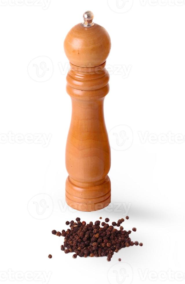 wooden manual pepperbox and scattered black pepper photo