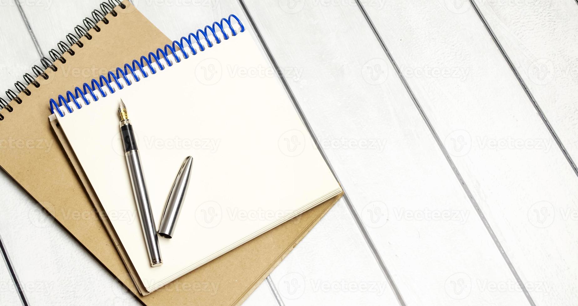 open notepads with pen on wooden background. Business concept photo
