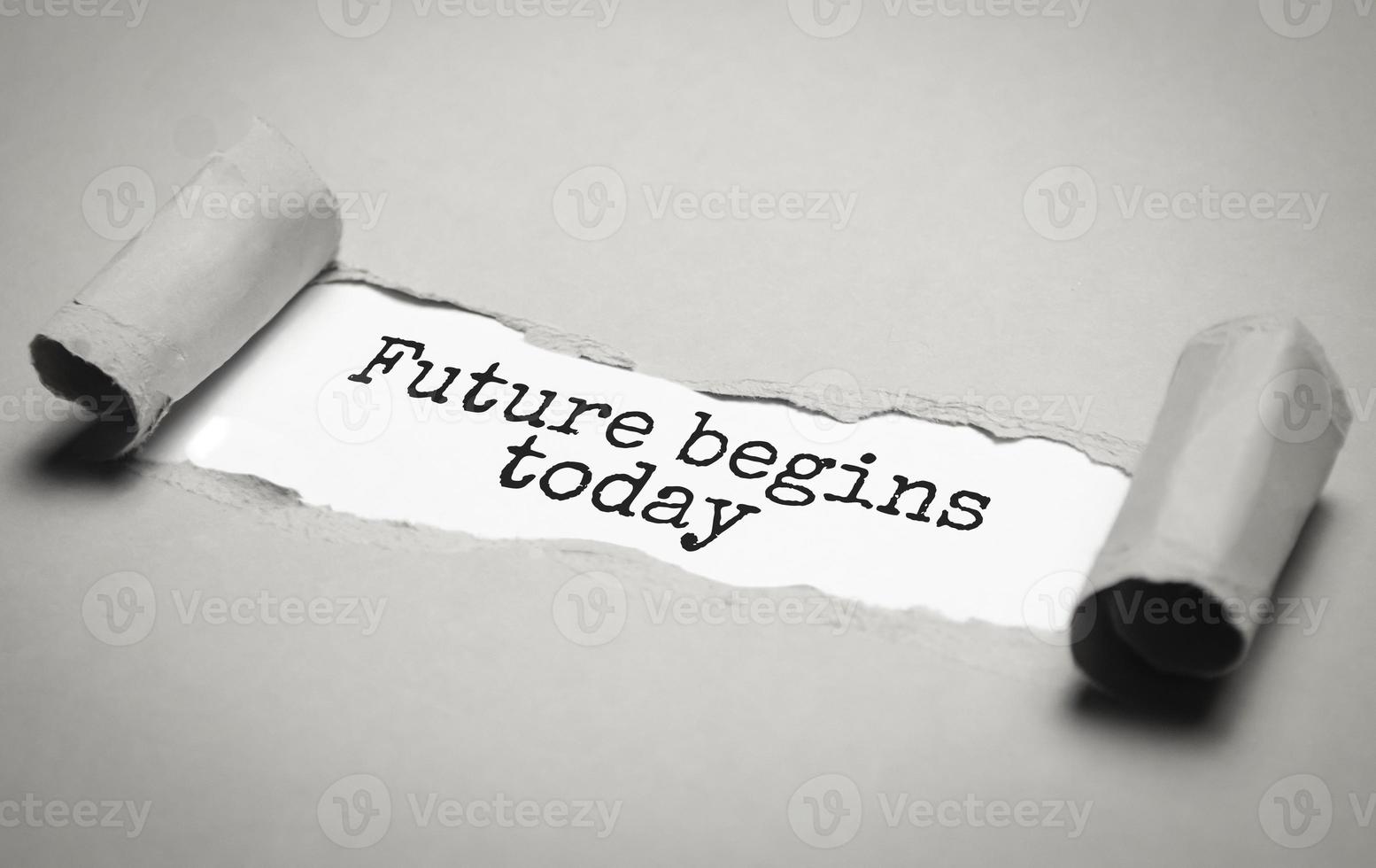 FUTURE BEGINS TODAY - text on torn paper on white desk in sunlight. photo