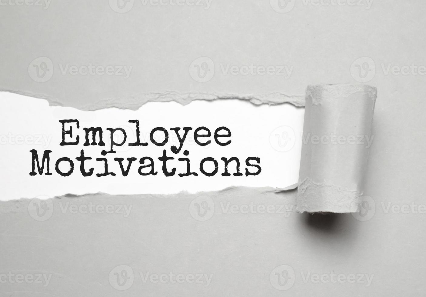 employee motivations - text on torn paper on white desk in sunlight. photo