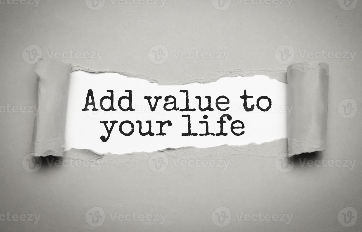 ADD VALUE TO YOUR LIFE - text on torn paper on white desk in sunlight. photo