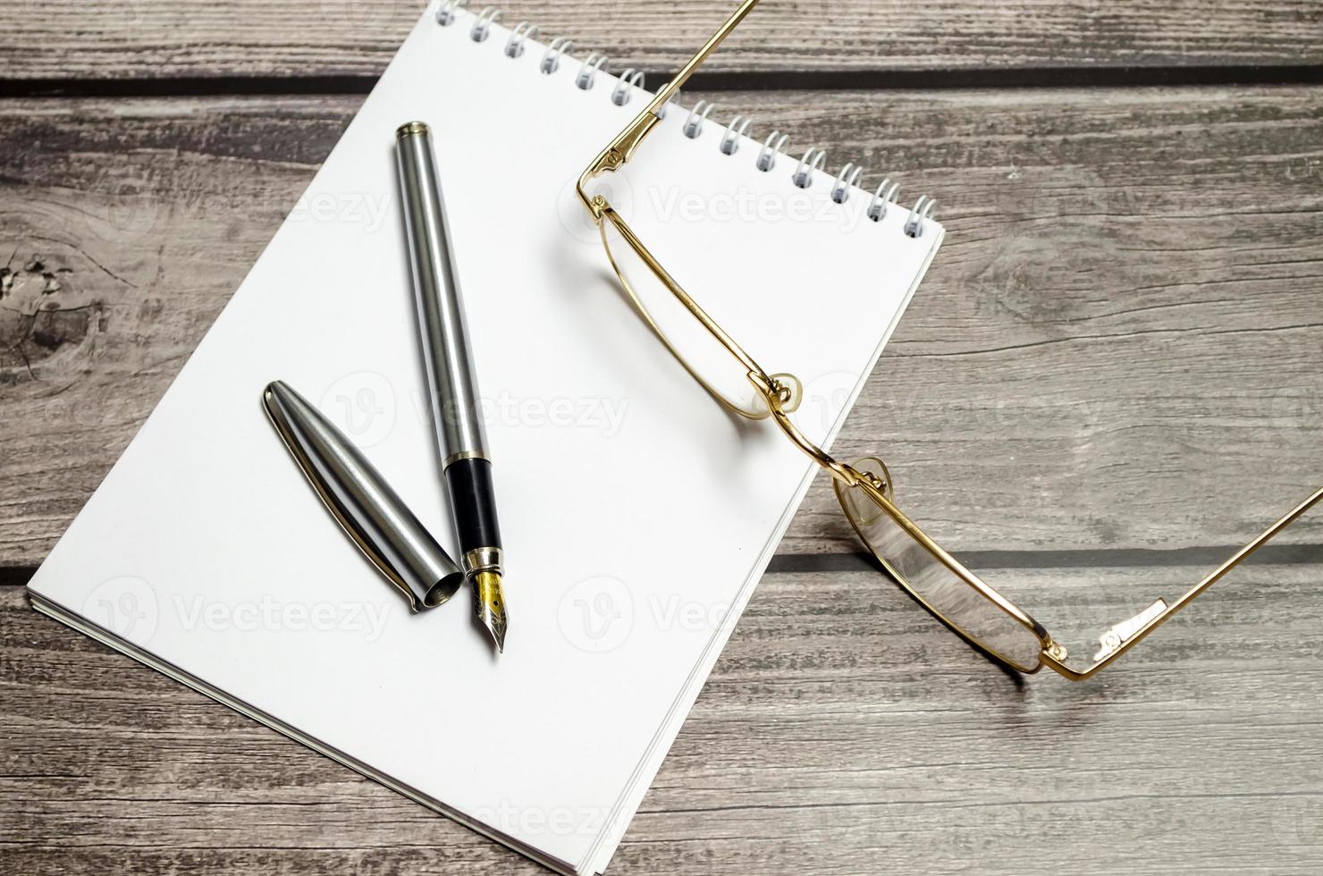 Blank notebook with pen are on top of white office desk table. Top view with copy space, flat lay. photo