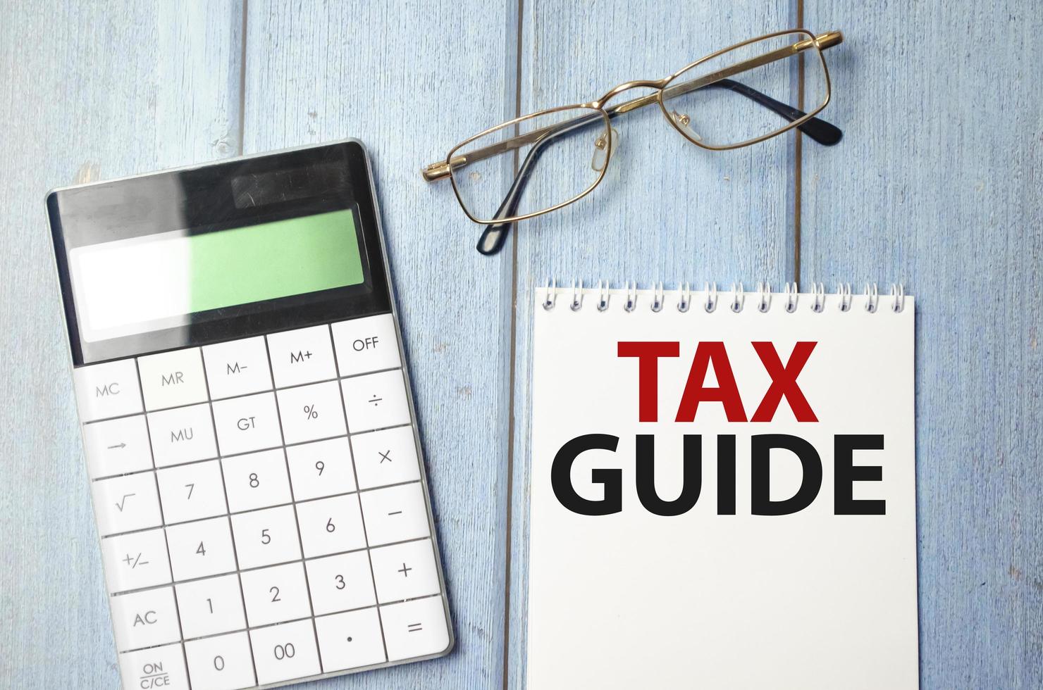 TAX GUIDE text on the paper sheet with chart, color paper and calculator photo