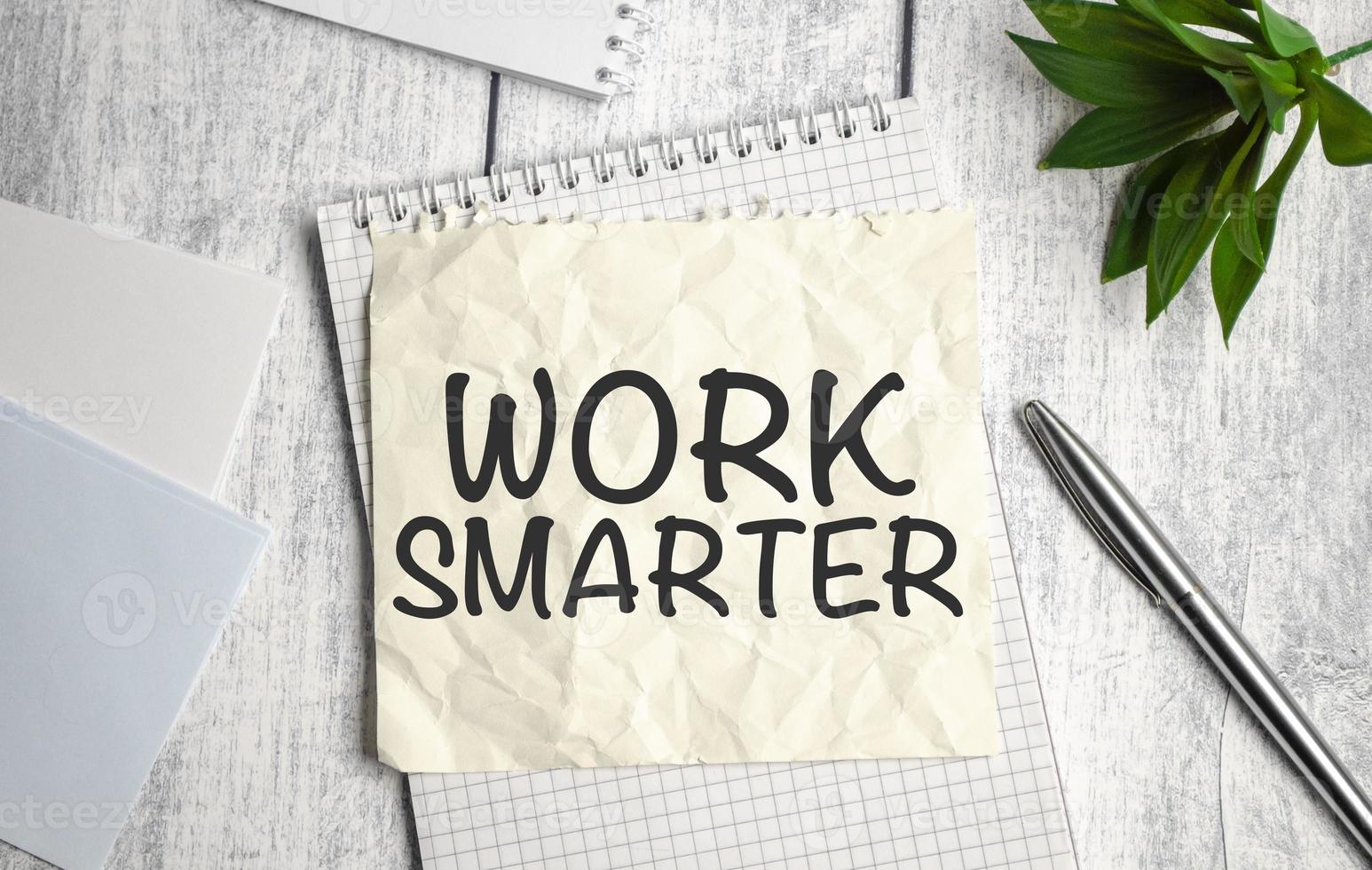 WORK SMARTER word on sticker on notepad with pen and calculator photo