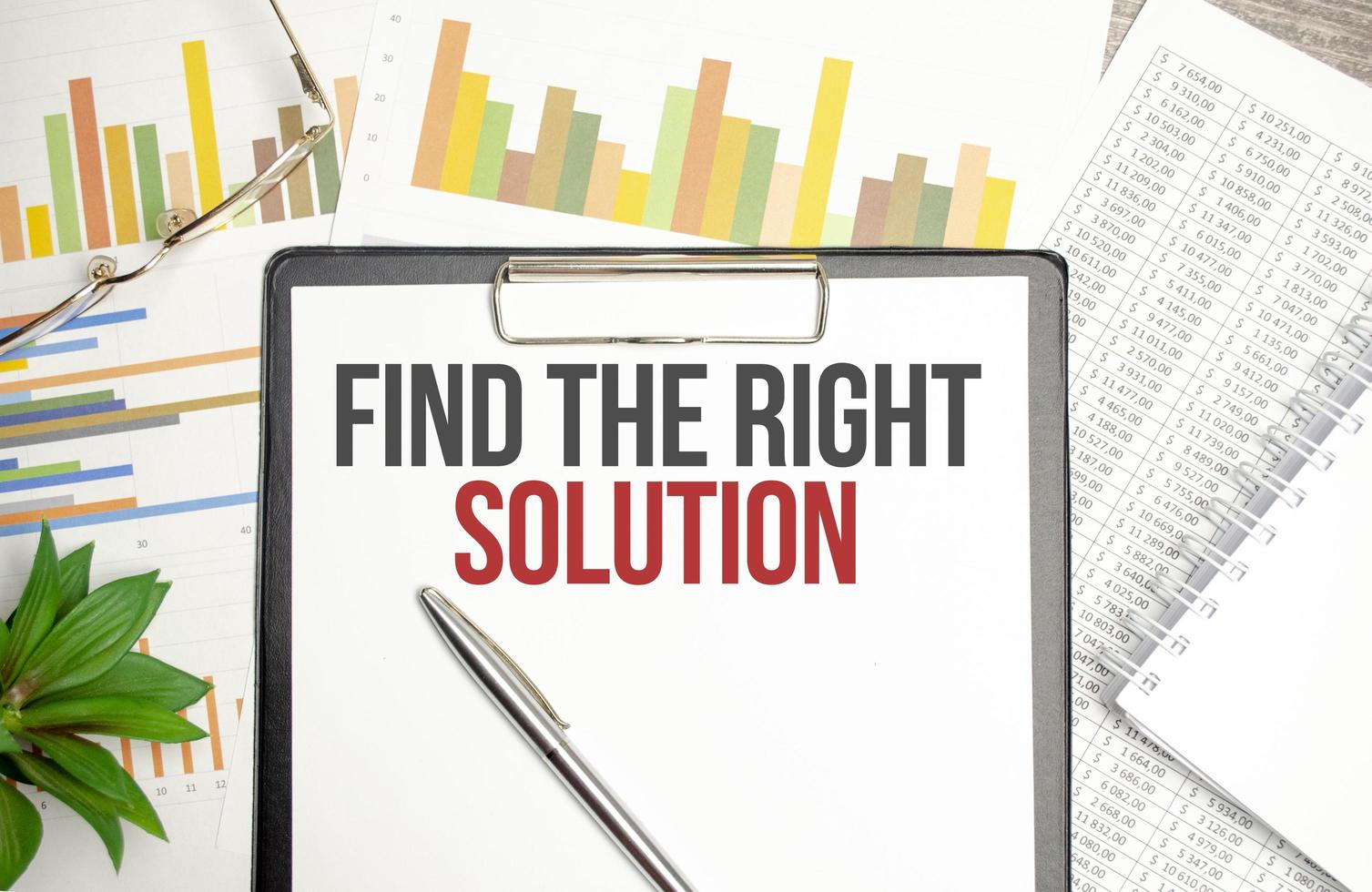 text Find The Right Solution on file folder with charts and pen photo