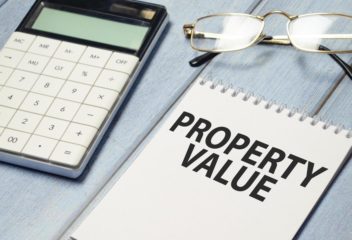 Property Value text on white notebook with calculator photo