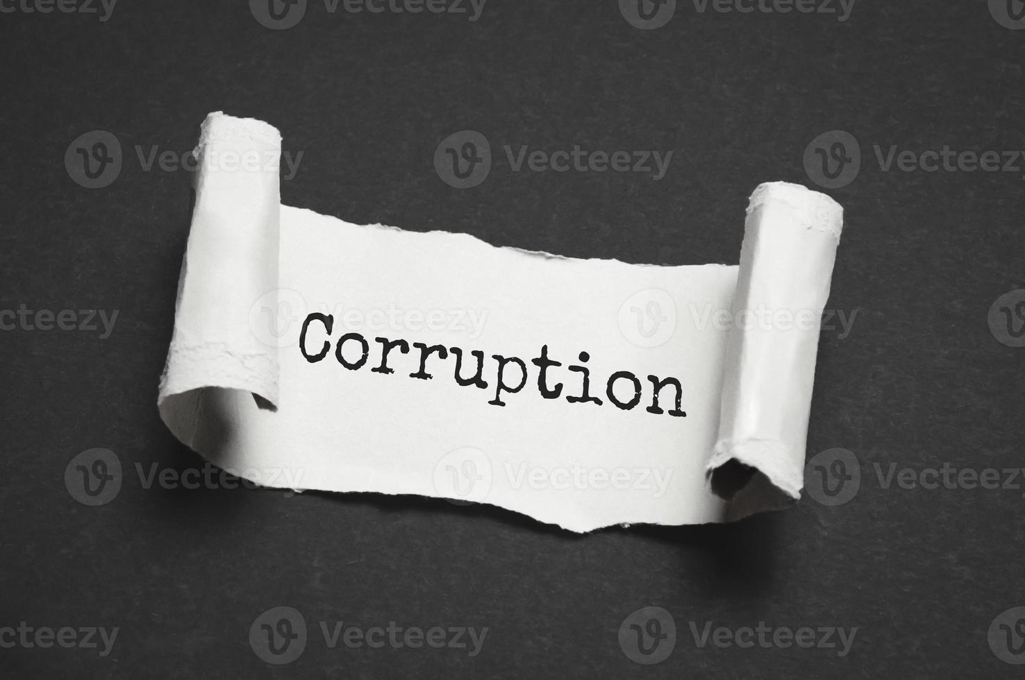 Torn pieces of black paper with the word Corruption. photo