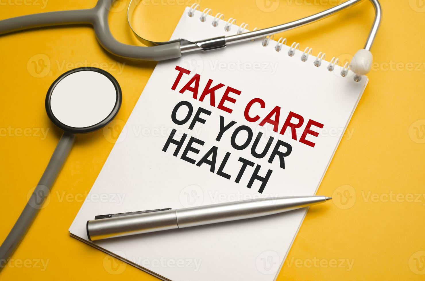 stethoscope, a pen and a notepad with the inscription Take care of your health photo