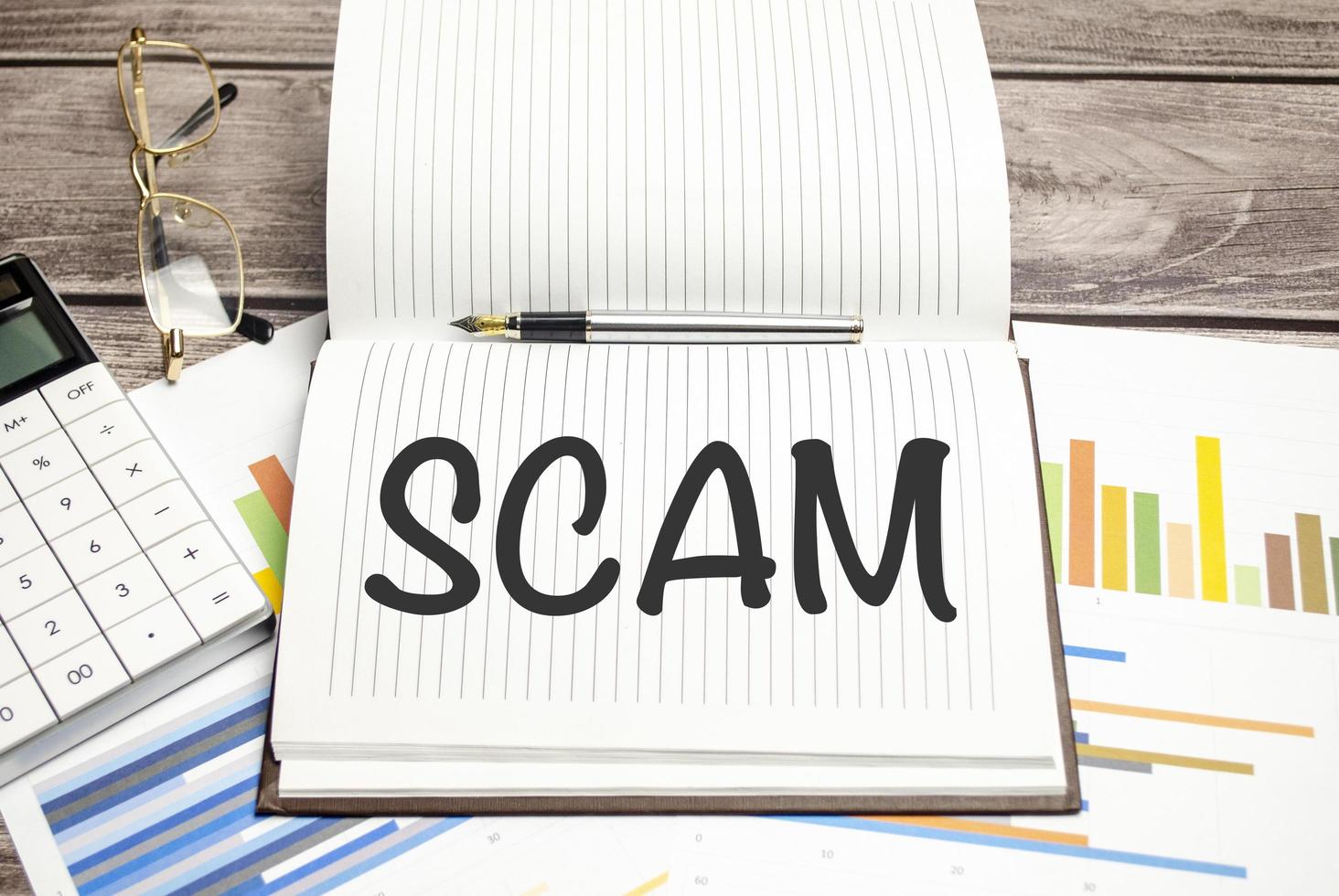Text scam on paper on the keyboard with office tools photo