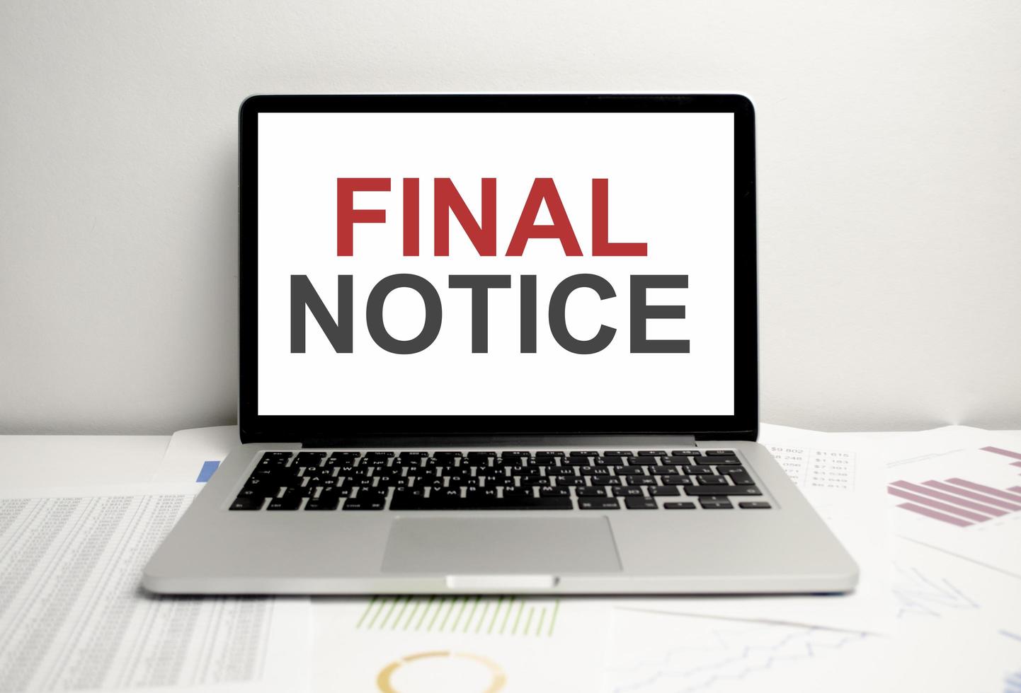 Final notice bills on laptop display on charts photo