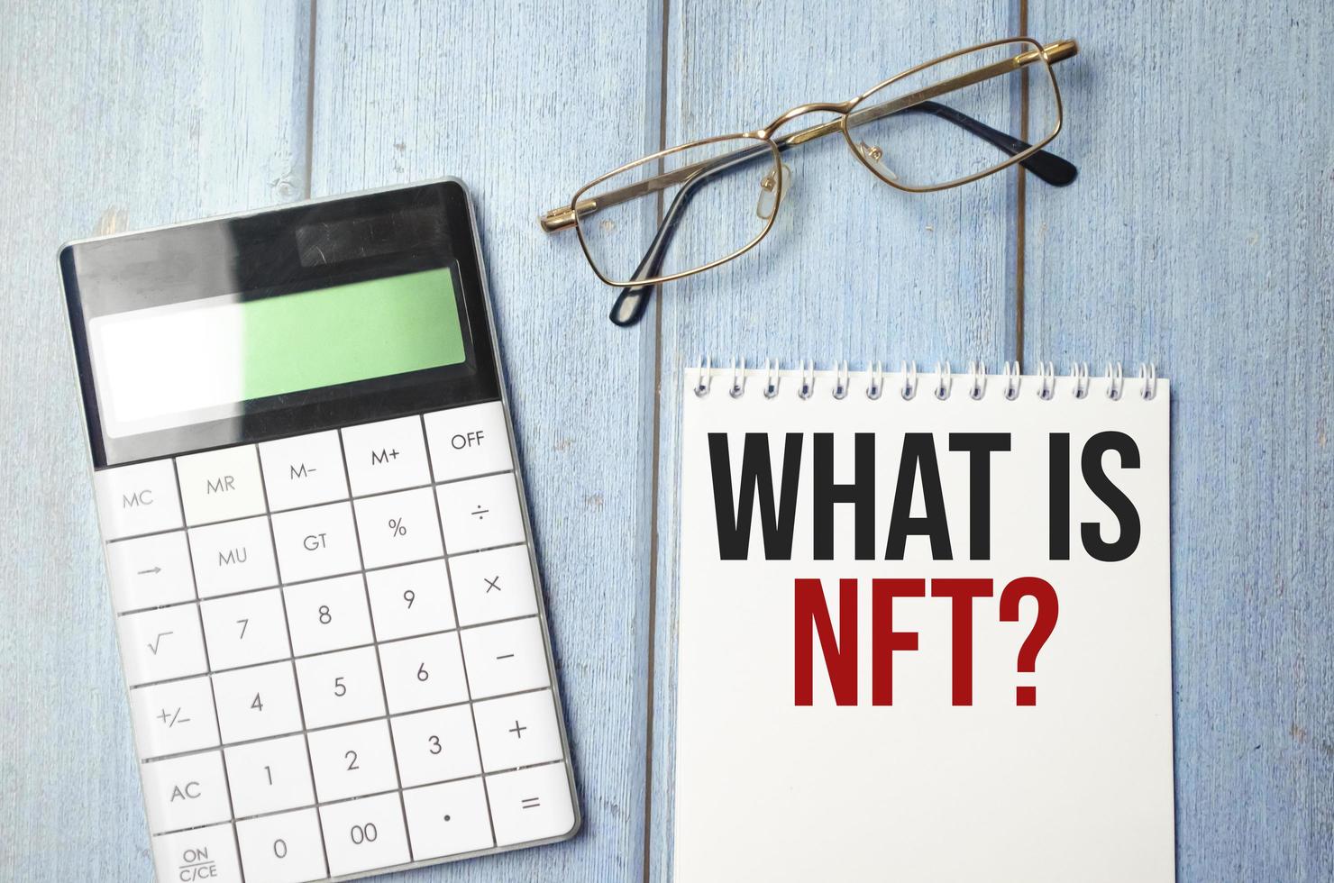 Paper with what is nft text on wooden background photo