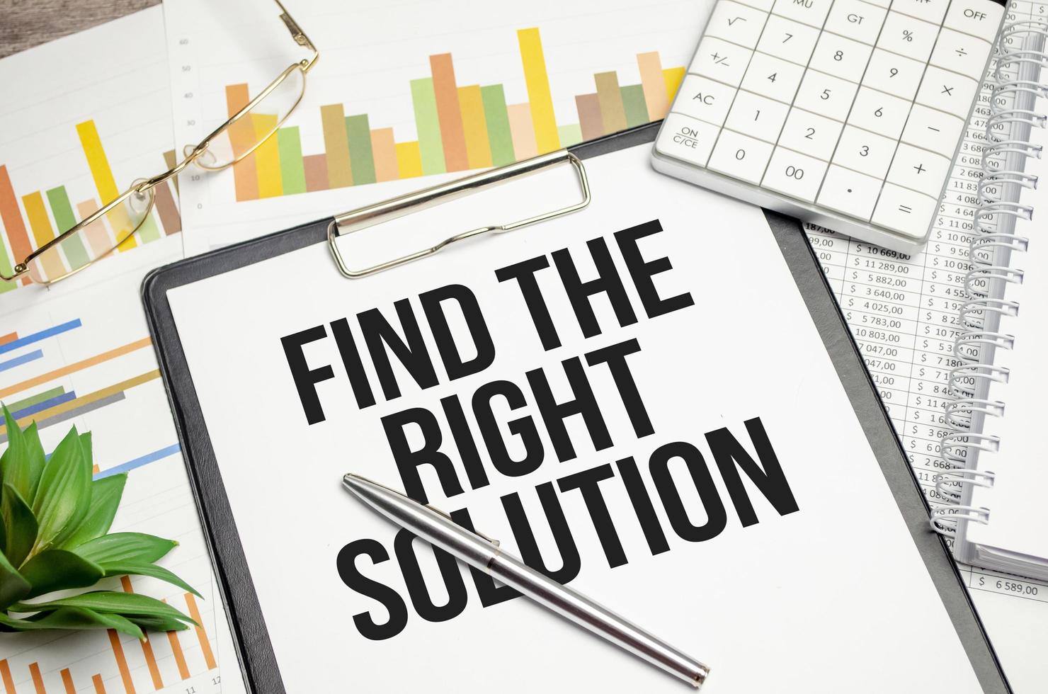 text Find The Right Solution on file folder with charts and pen photo