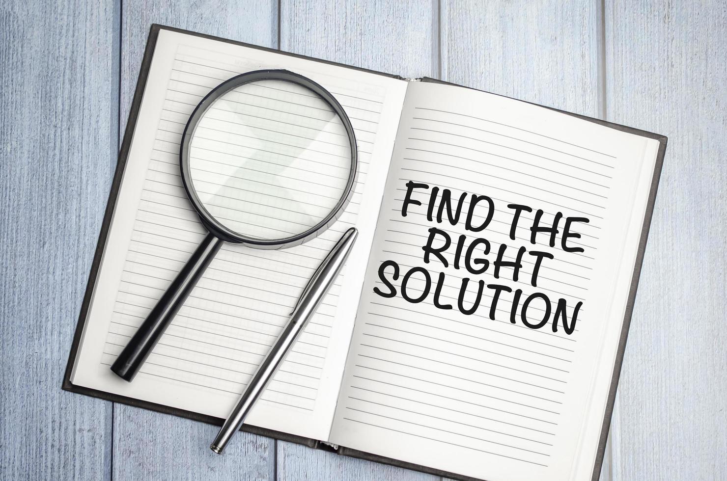 magnifying glass and a white notebook with the text Find The Right Solution photo