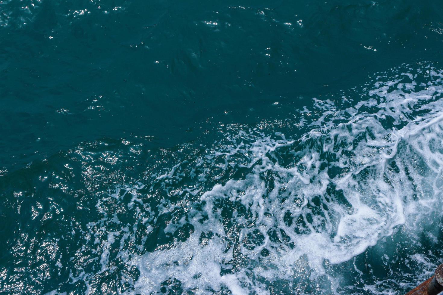 Beautiful sea waves with foam of blue and turquoise color. Abstract blue sea water with white wave. Blue and white waves of the ship road on the water sea ocean. photo