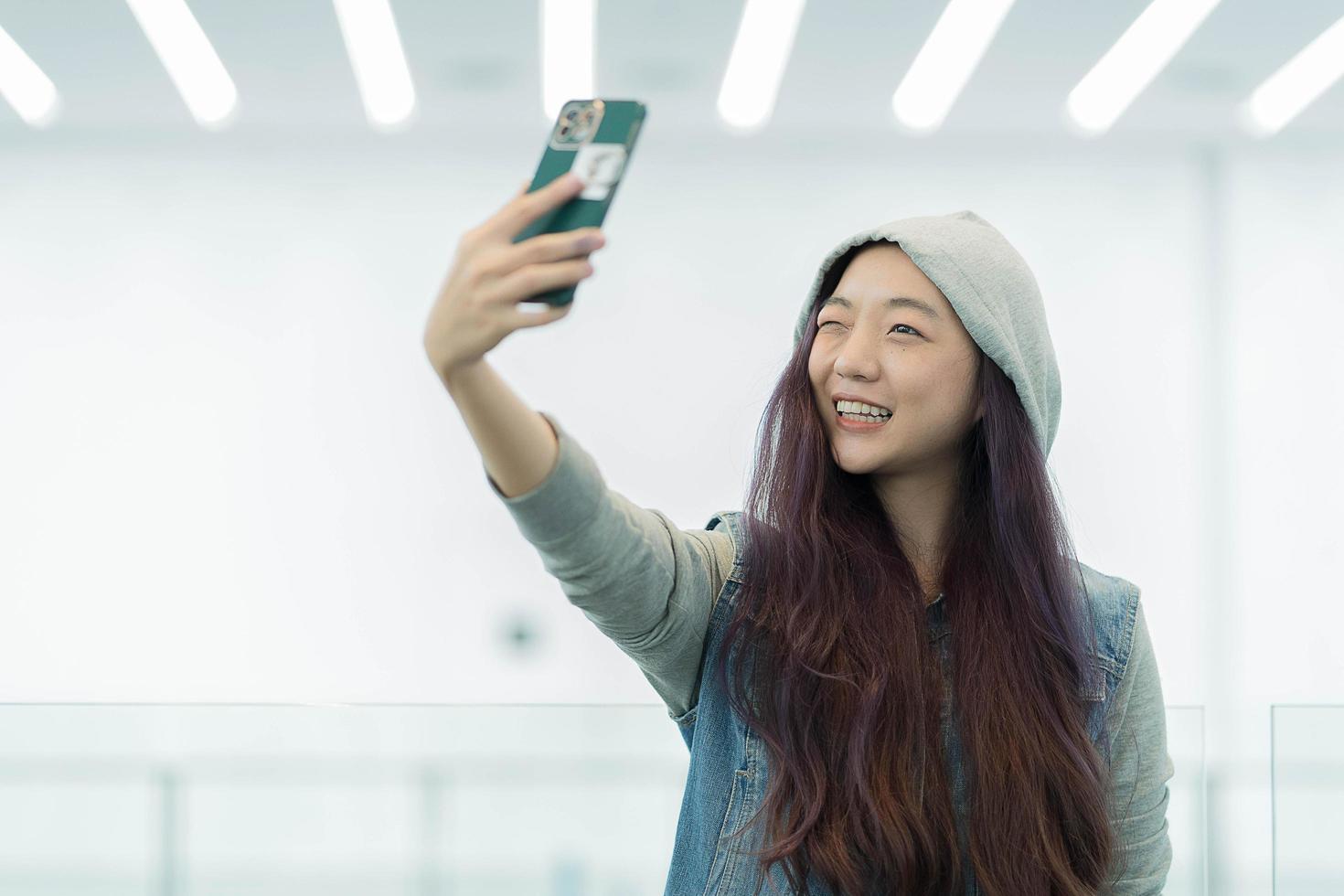 hermoso retrato joven mujer asiática tomando un selfie con un teléfono móvil inteligente, la chica está fotografiando con felicidad y sonrisa con diversión, concepto de estilo de vida. foto