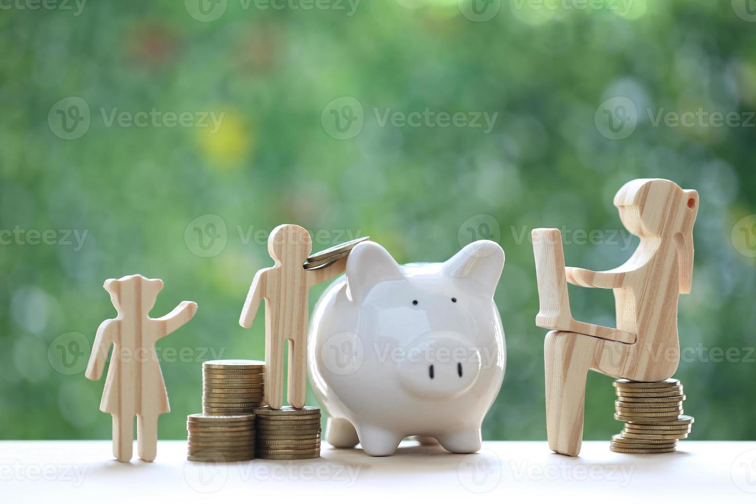 Investment and business concept,Woman using laptop computer and piggy banks with stack of coin money on natural green background,Investors strategy photo