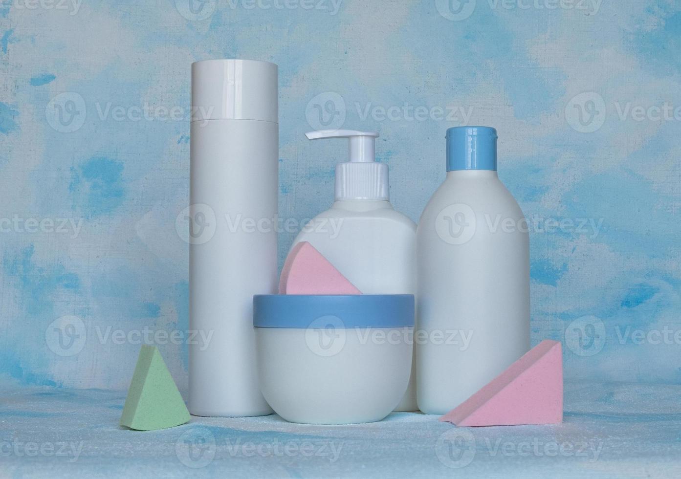 Bottles for cosmetic products without a label. Facial skin care concept. Background texture. Sponges for makeup photo