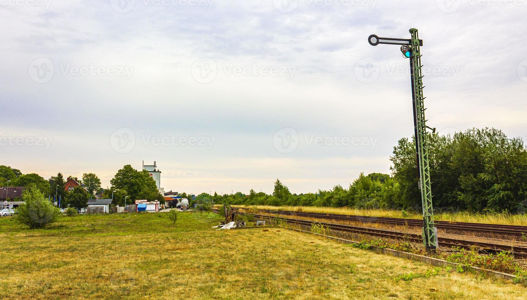 Green and peaceful train station building and railroad tracks Germany. photo