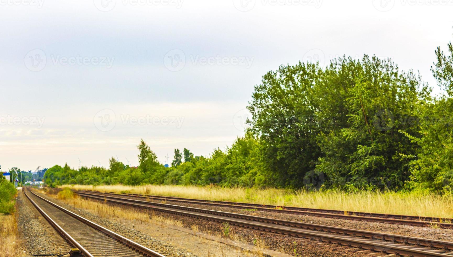 Green and peaceful train station building and railroad tracks Germany. photo