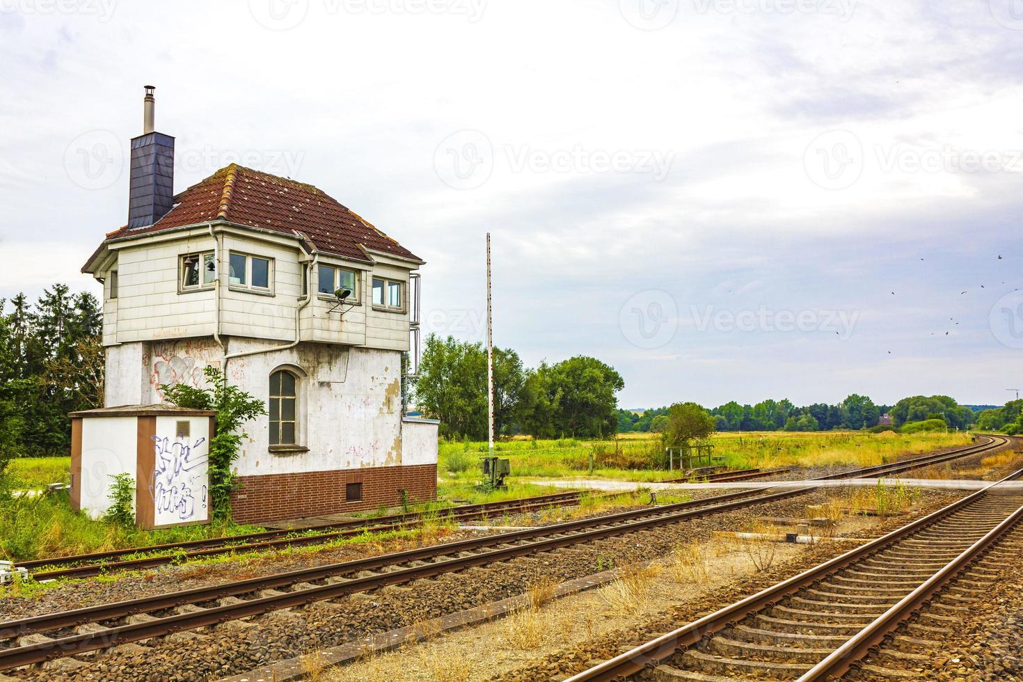 Green and peaceful train station building and railroad tracks Germany. photo