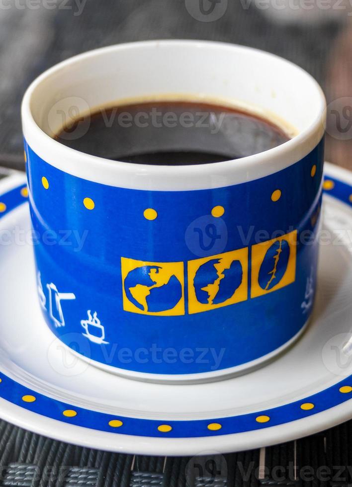 café negro en una taza azul con globos terráqueos, tailandia. foto