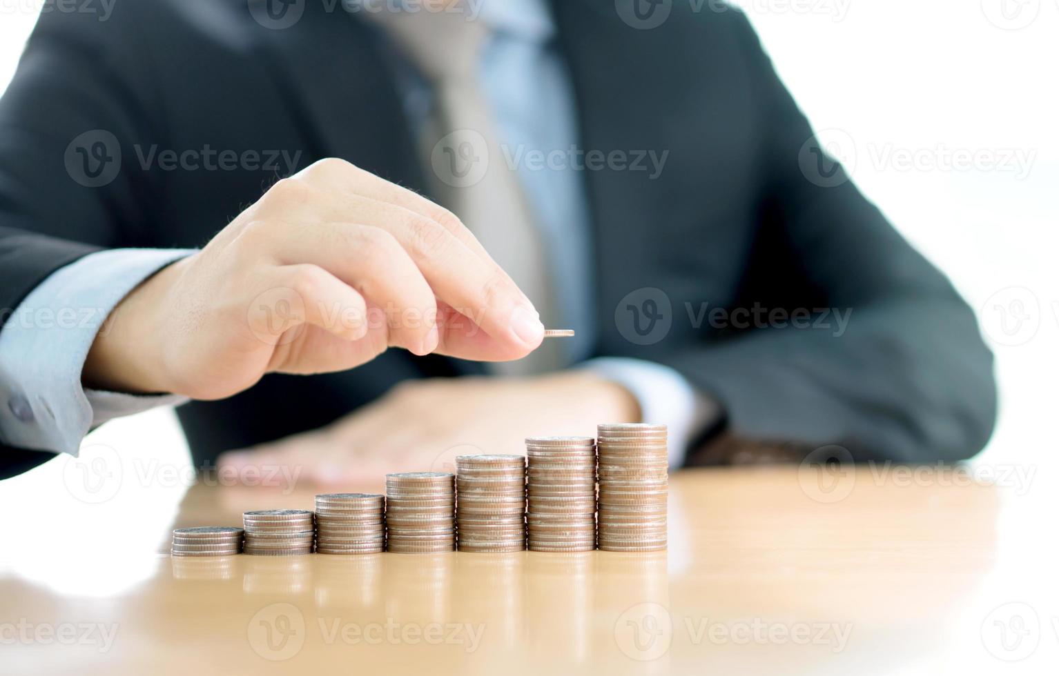 Close-up Of A Businessman Making Stack Of Coins photo