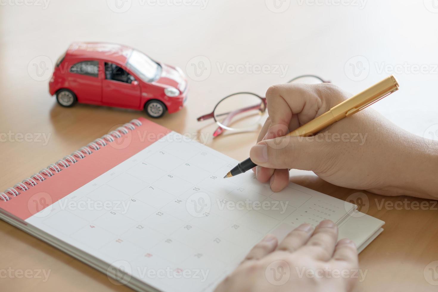 hand holding pen and marking on calendar photo