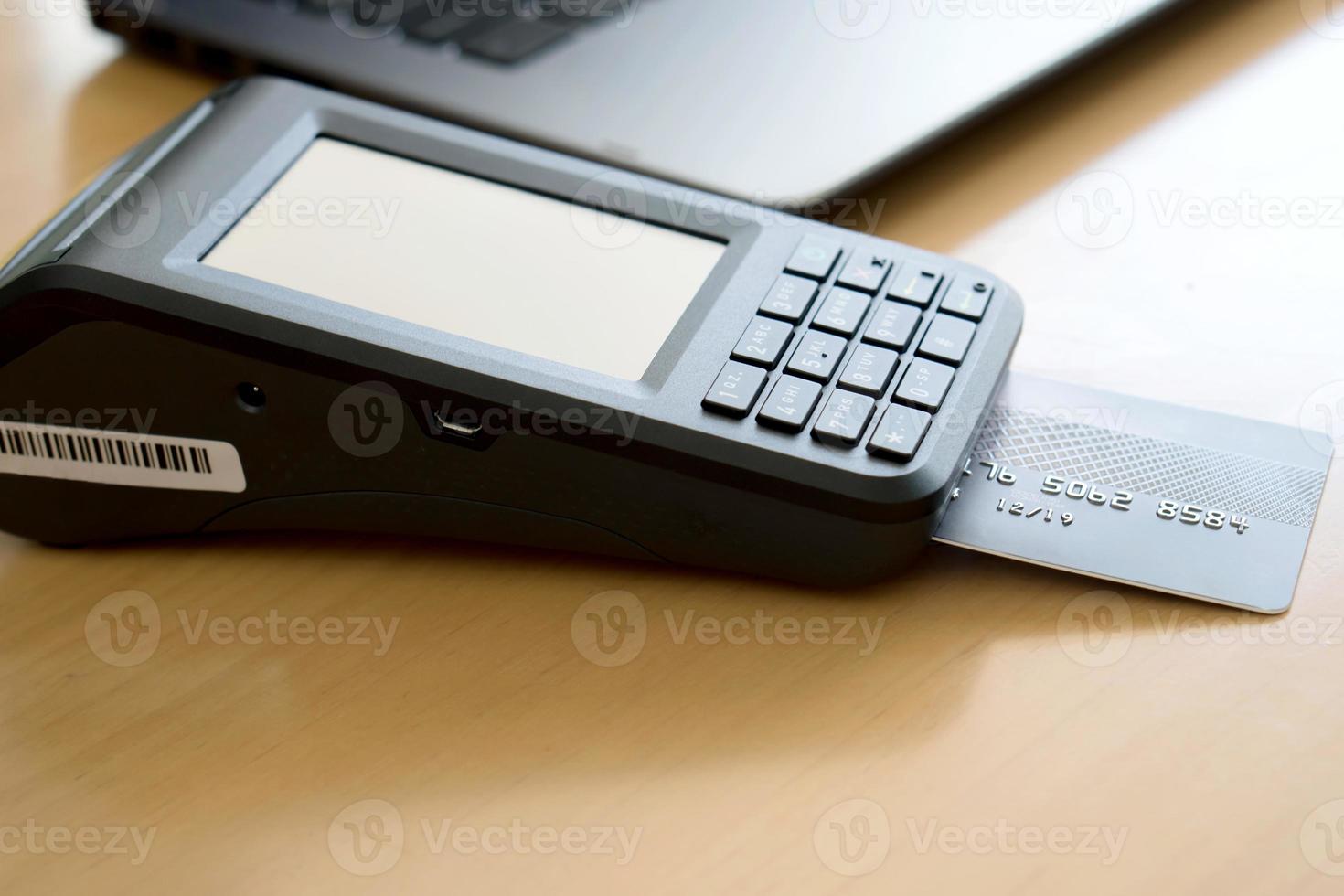 Payment terminal with contactless credit card and laptop, finance concept photo