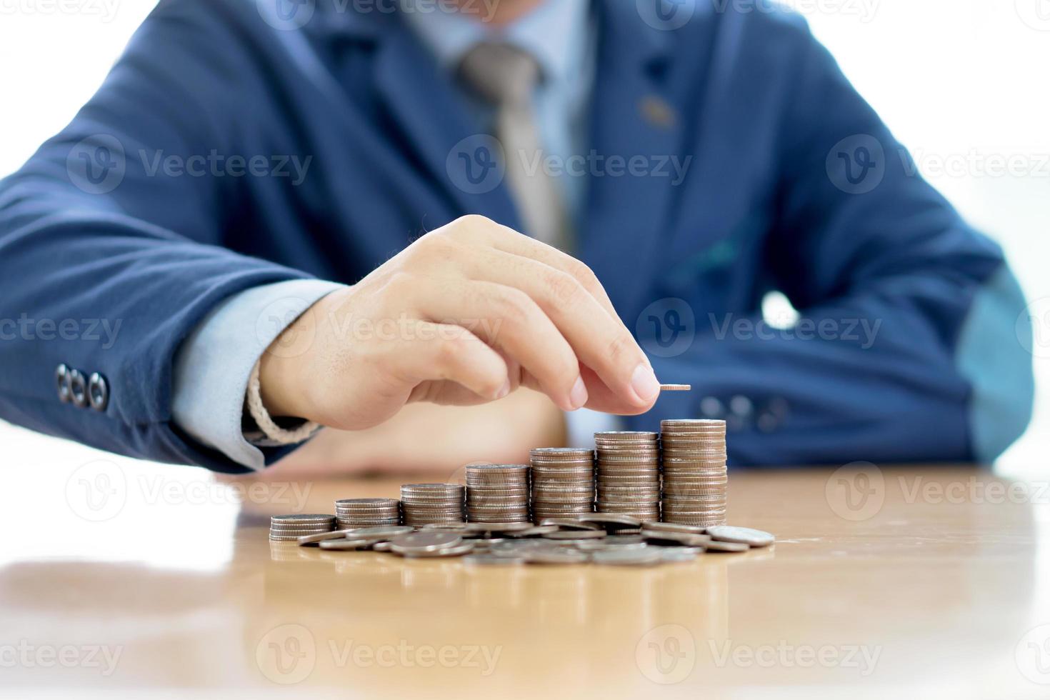Close-up Of A Businessman Making Stack Of Coins photo