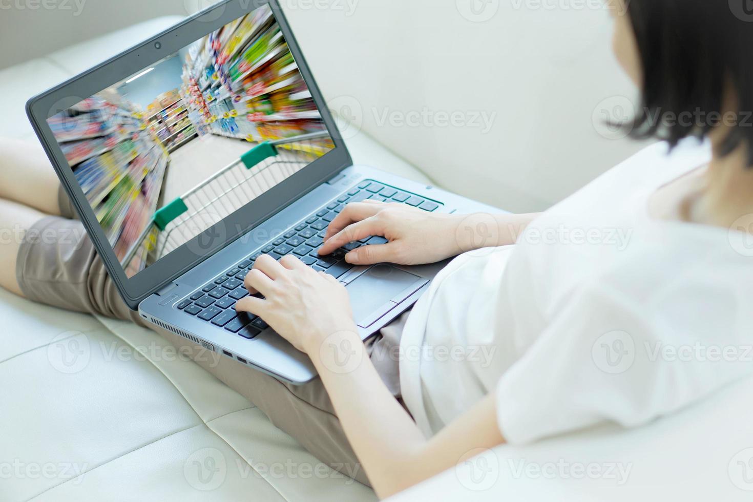Hand typing laptop with blur supermarket on screen photo