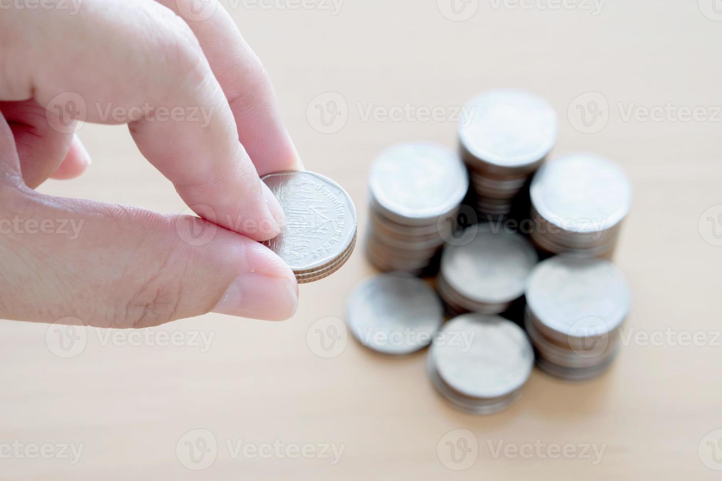 Hand giving coins into stack. photo