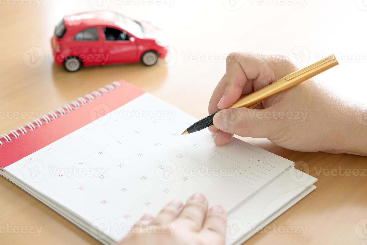 hand holding pen and marking on calendar photo